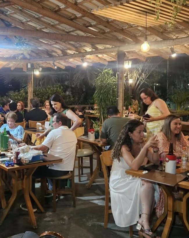 Salão do Sagarana com mesas ocupadas à noite
